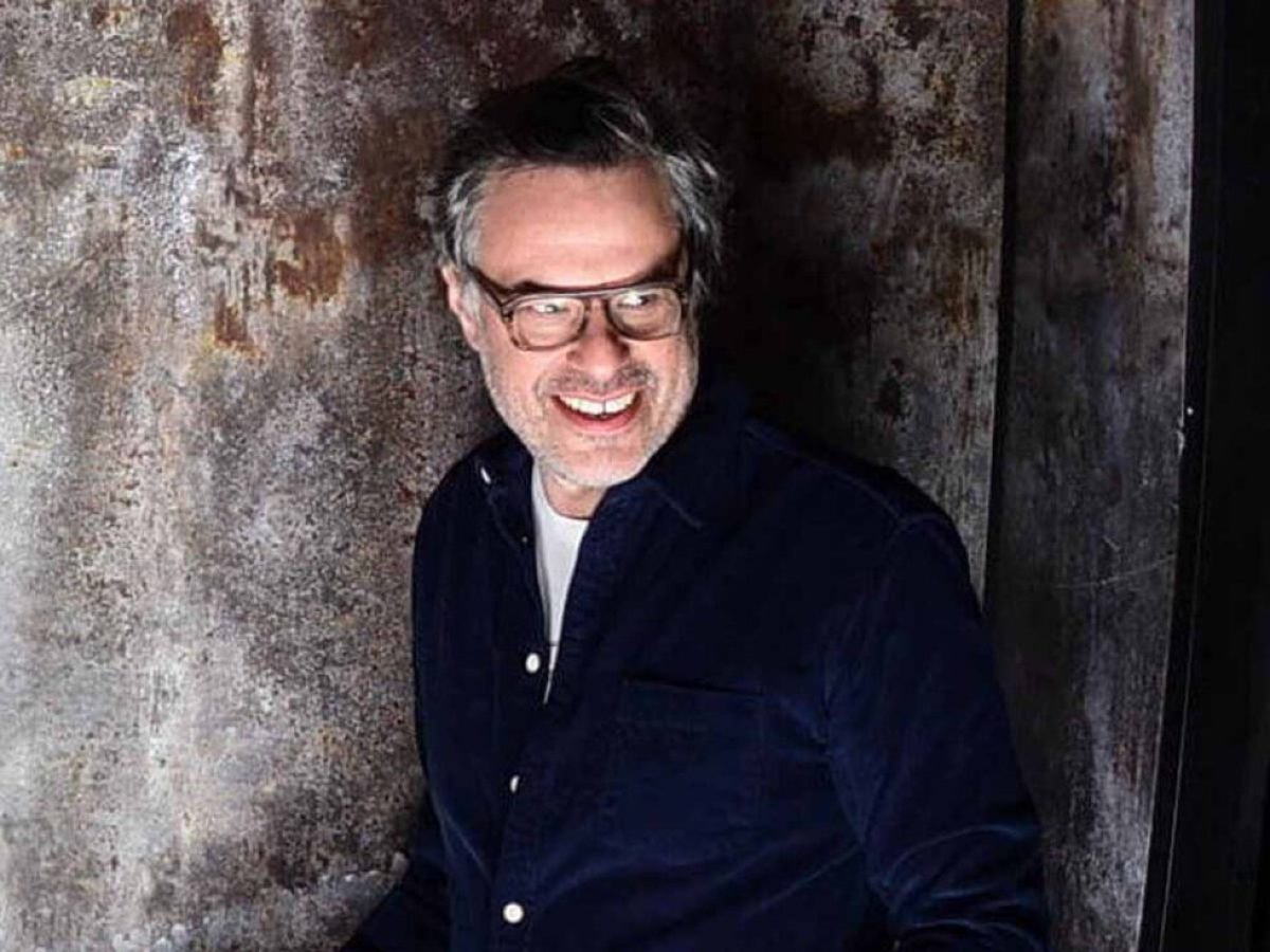 Jemaine Clement standing in front of a brick wall