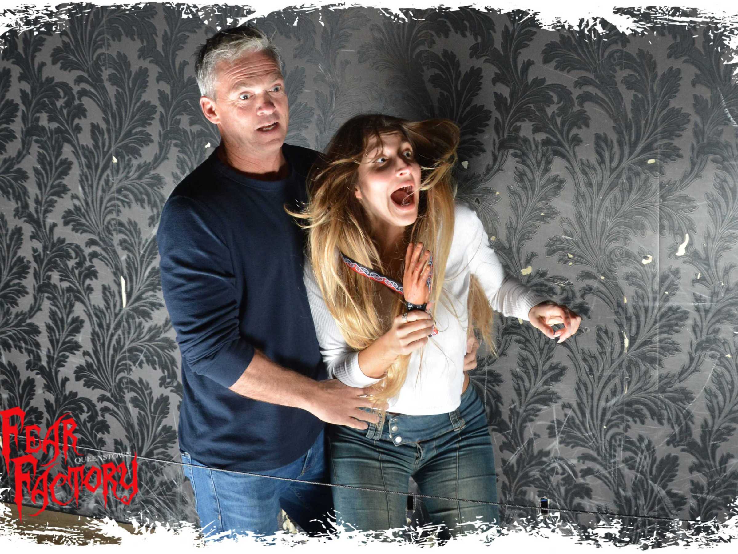 Two startled people reacting inside a haunted house attraction.