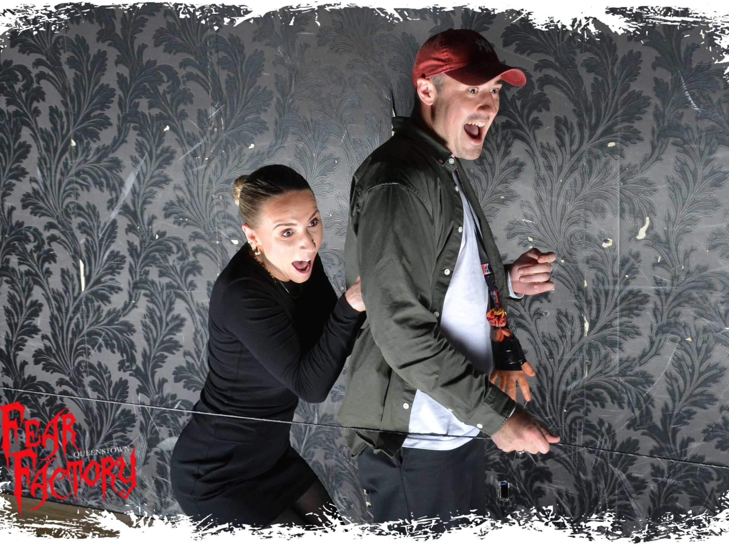 Two people look startled in a horror-themed photo.