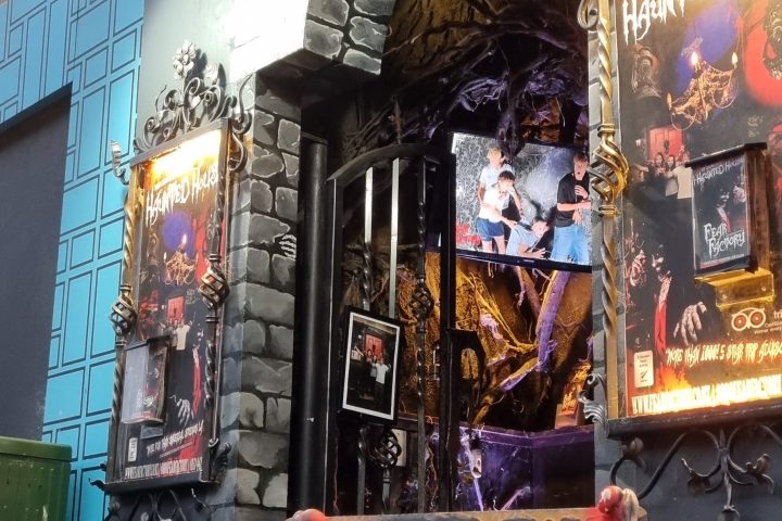 Spooky bar entrance with skeleton decor and neon sign.