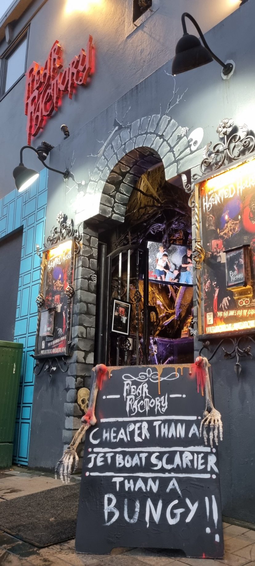 Spooky bar entrance with skeleton decor and neon sign.