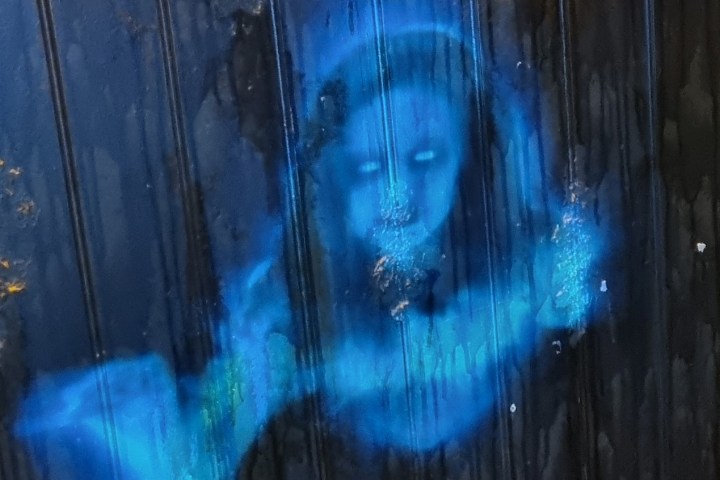 Blue ghostly figure on a dark textured surface.